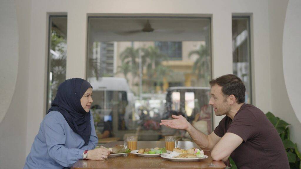 a man and a woman sitting at a table eating food