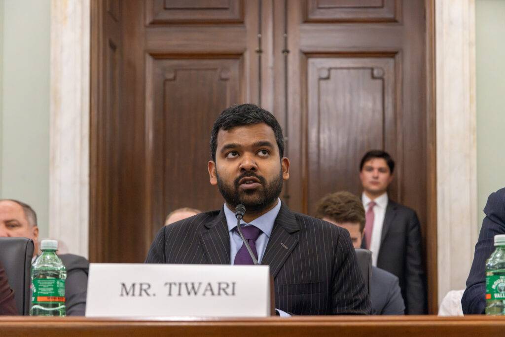 Udbhav Tiwari, Mozilla's Director of Global Product Policy, testifying at a Senate committee hearing on privacy and AI, seated at a table with a microphone and nameplate.